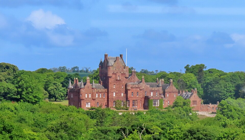 Ayton Castle, built in red sandstone, a huddle of buildings with pointy roofs, surroudned by greenery