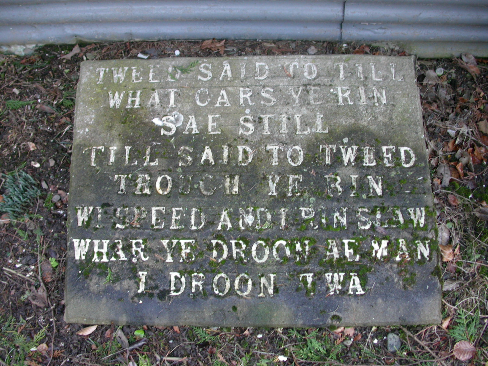 A stone plaque with very weathered white lettering. text is given below