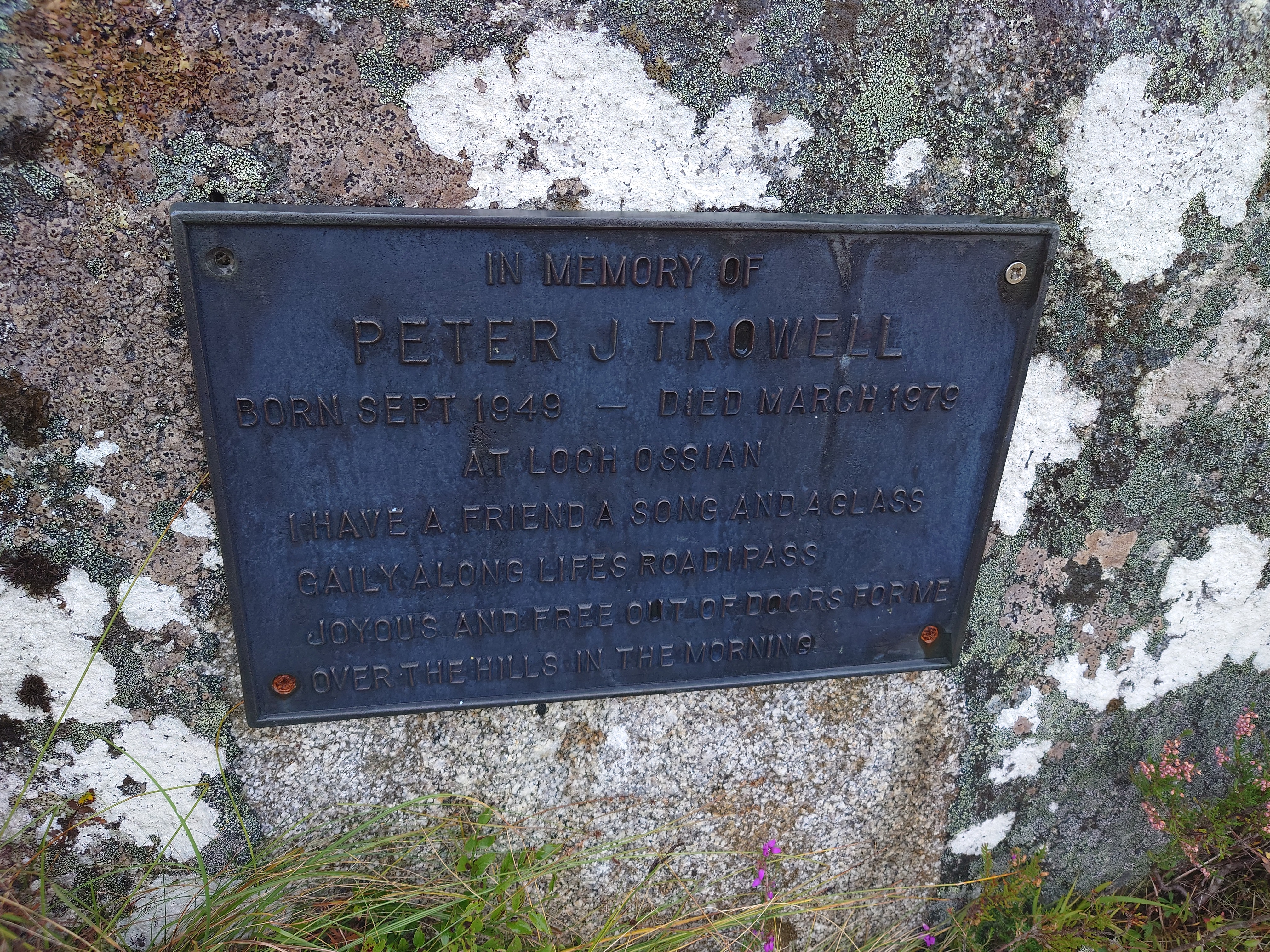 A bronze plate is fixed to a rock. The text is in the caption below.