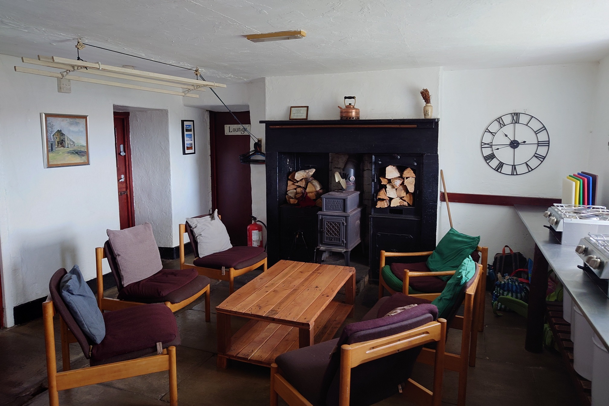 Inside, an extremely cosy kitchen with armchairs around a low coffee table and a substantial wood burning stove.
