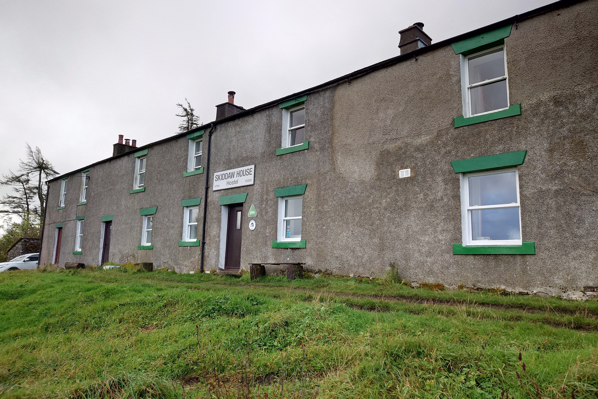A terraced row of what was once three or so pebbledashed houses, with the window lintels painted green. Would not look out of place on a council housing estate.